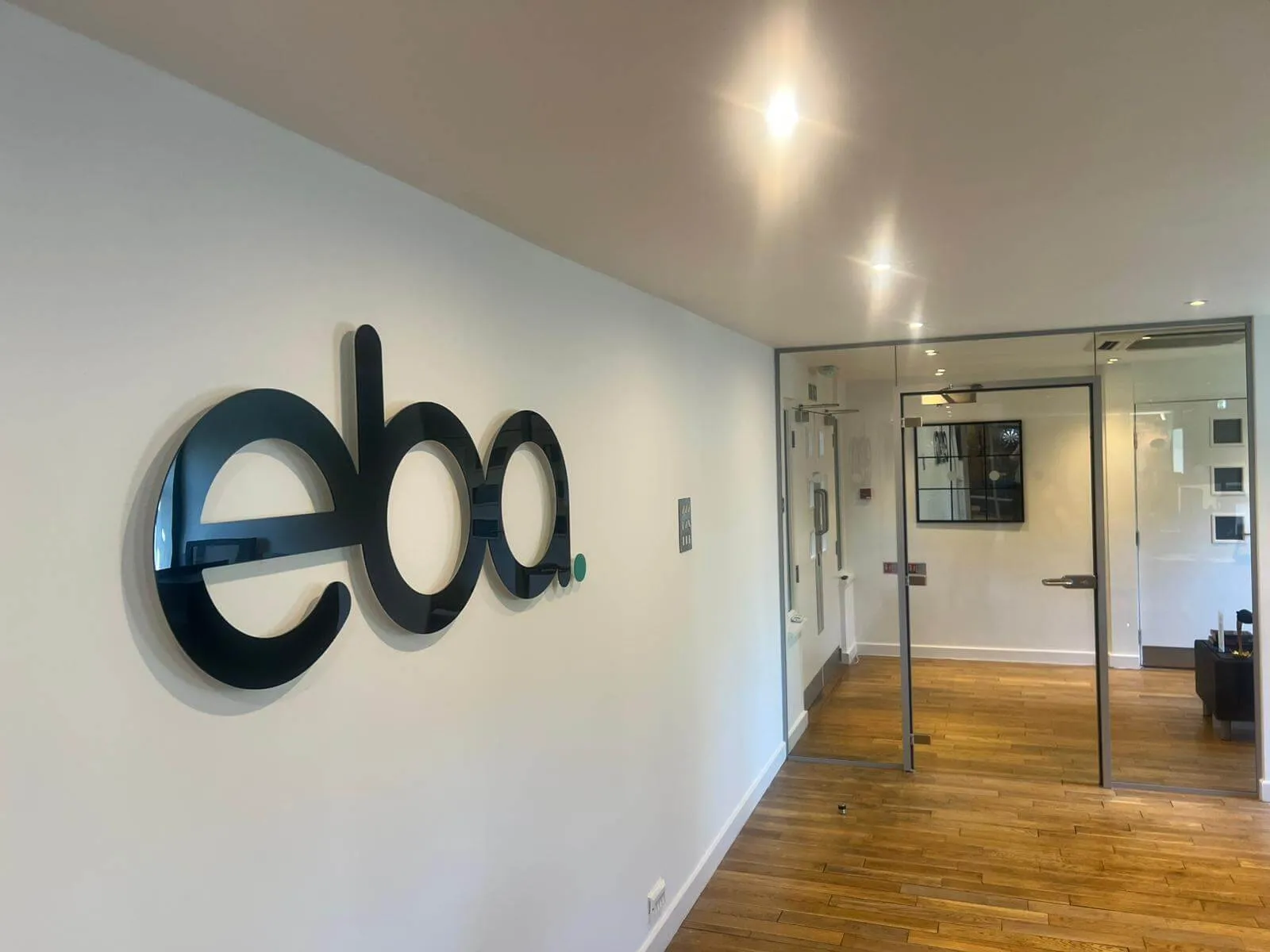 The eba wordmark mounted on the reception wall of the firm's converted barn office in Knutsford.